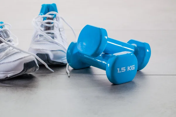 Gym concept with running sneakers and weights for wellness lifestyle