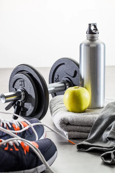 To work out with dumbbells, aluminium bottle and healthy apple