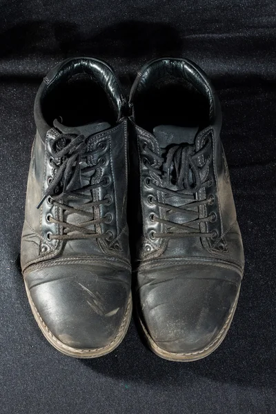 Old worn out shoes on the background