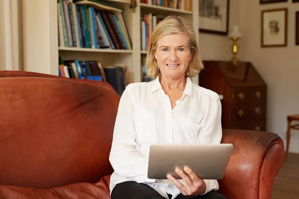 Woman using tablet on leather sofa