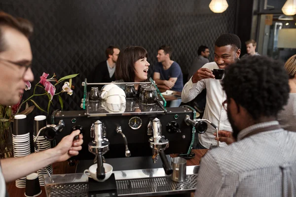 Woman laughing with African friend at counter