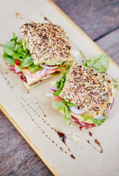 Fresh sandwiches on rustic wooden board
