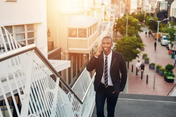 Businessman talking on phone while walking