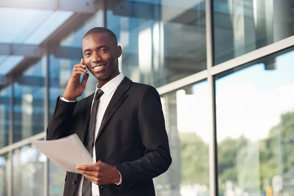 Businessman holding file and using phone