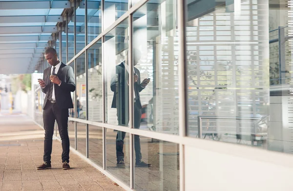 Businessman reading message outside office