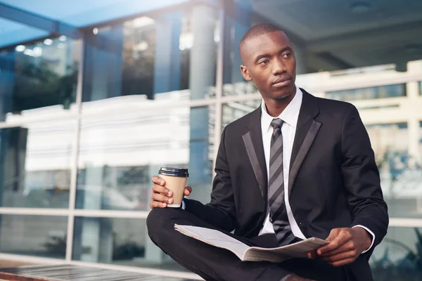 Businessman sitting with coffee and newspaper