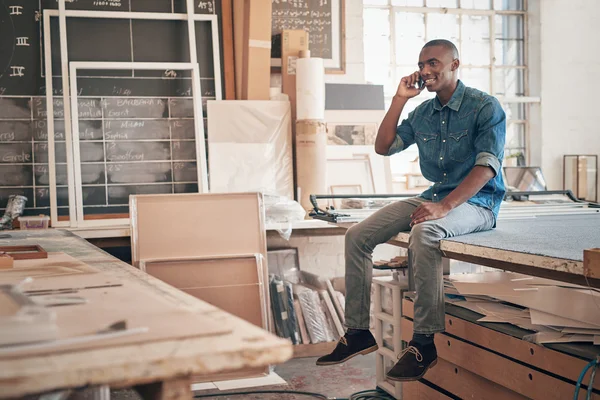 African designer talking on phone in studio