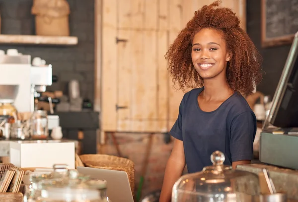 Woman using laptop while working in cafe