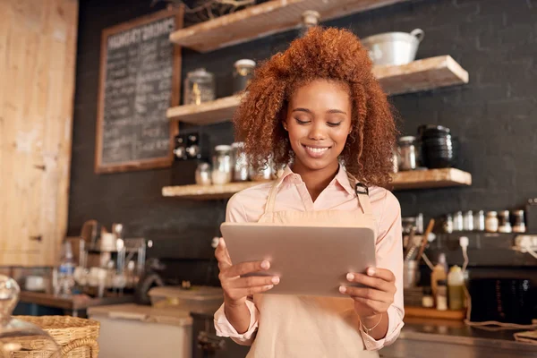 Woman using tablet while working in cafe