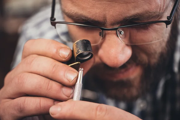 Jeweler using loupe to examine diamond