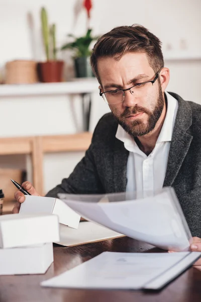 Entrepreneur reading paperwork and preparing packages