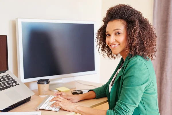 Businesswoman typing on computer at desk