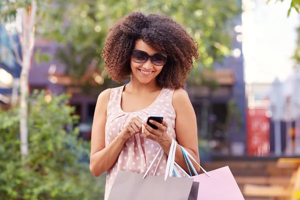 Woman in sunglasses sending message on phone