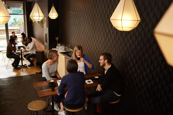 Friends sitting at table in modern cafe