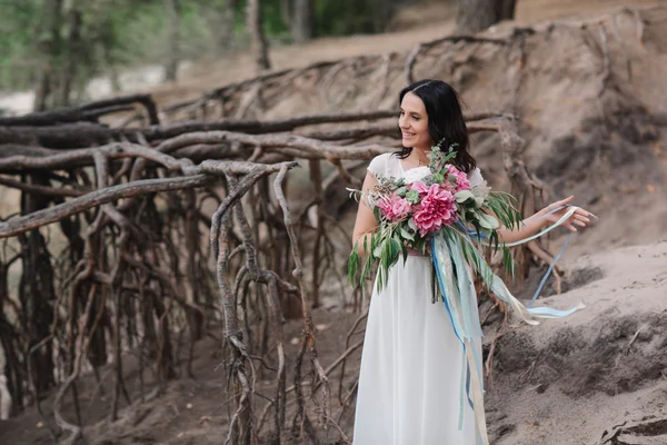 Beautiful girl with a bouquet of flowers is a bouquet on the beach