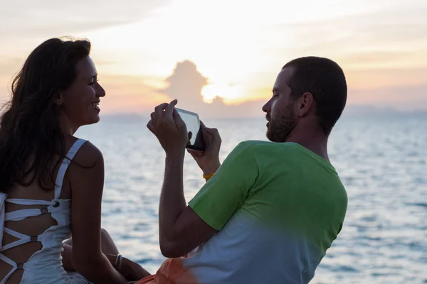 Young mixed couple are photographed on the tablet