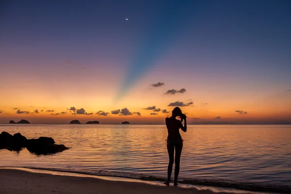 Young woman stay on the beach by the sea and watching the sunset on a tropical island Koh Samui, Thailand