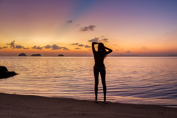 Young woman stay on the beach by the sea and watching the sunset on a tropical island Koh Samui, Thailand