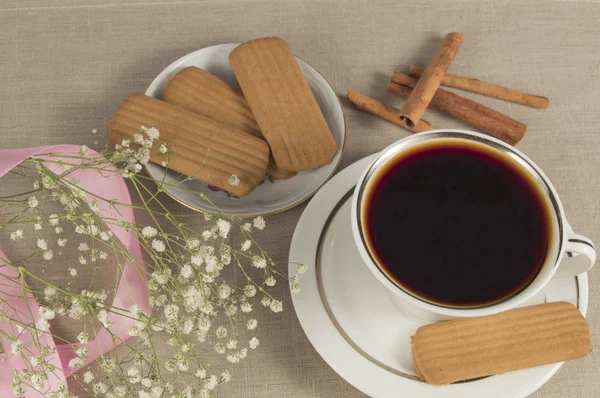 Hot Cup of coffee, cinammon cookies with sprigs of gypsophilla and pink ribbon
