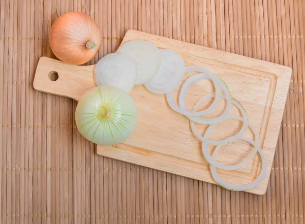 Bulb onions sliced on wooden cutting Board, top view