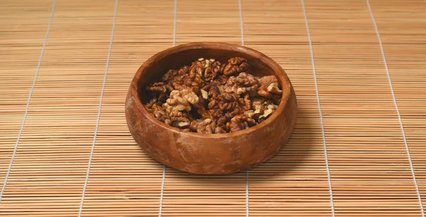 Peeled walnuts in wooden plate on the bamboo napkin