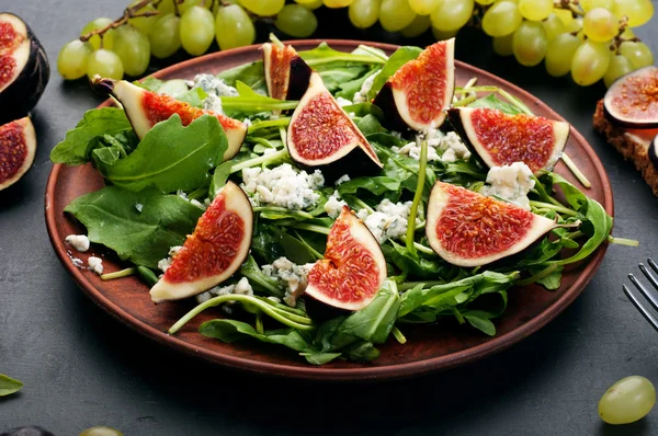 Light summer salad with arugula, figs and blue cheese. Low-calorie nutritious ready-made meal. Autumn menu