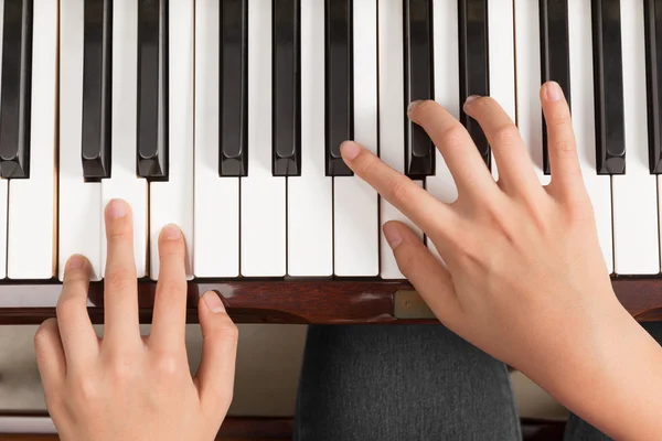 Top view close up of female hands playing piano
