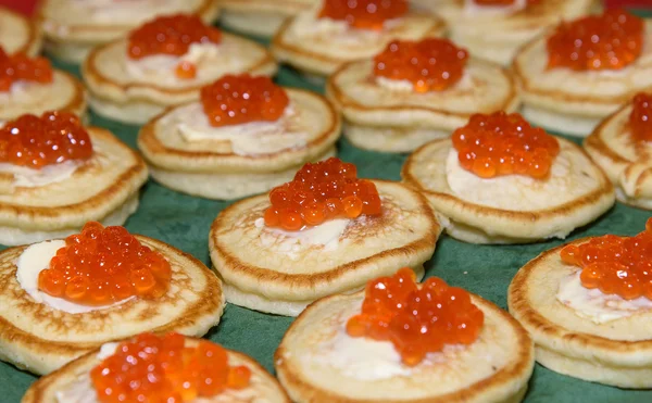 Red caviar and sour cream on pancakes. Delicious appetizer. Russian national cuisine