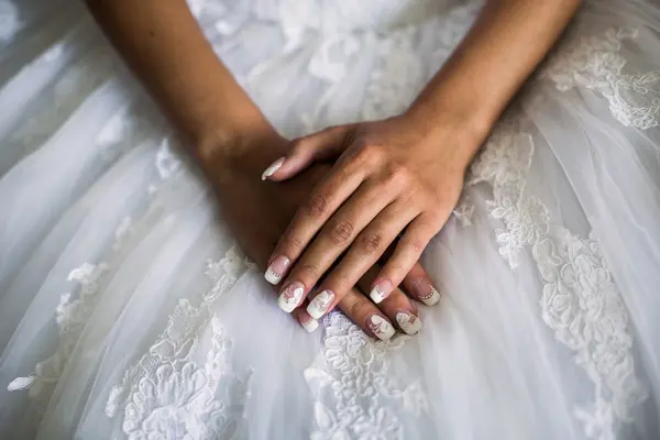 Female hands on the wedding dress, the bride morning, preparing for the wedding