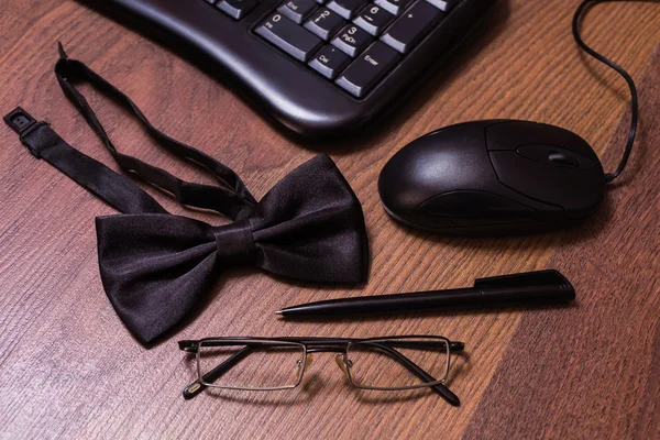 Keyboard and mouse, glasses, black bowtie black pen, note book page and money