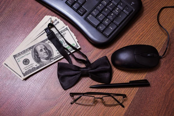 Keyboard and mouse, glasses, black bowtie black pen, note book page and money