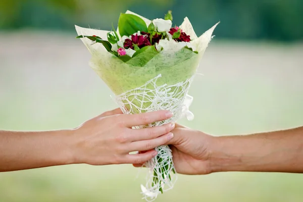 Boy gives a girl a bouquet close-up