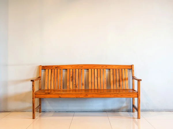 Wooden bench against the concrete wall