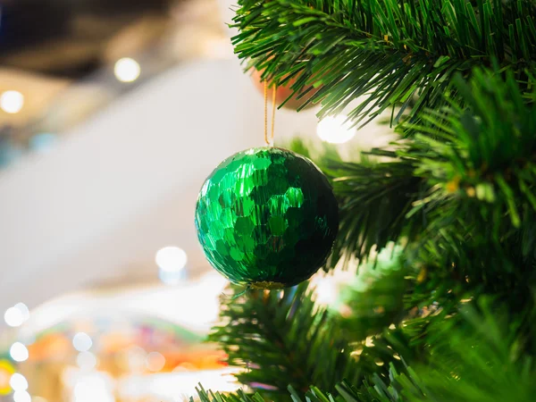 Green Christmas ball on Christmas tree, selective focus