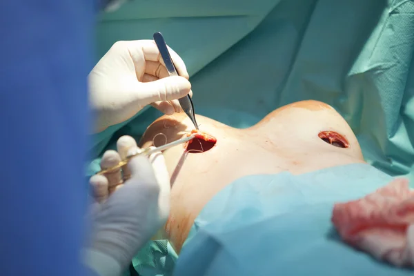 Breast augmentation surgery in the operating room surgeon tools implant