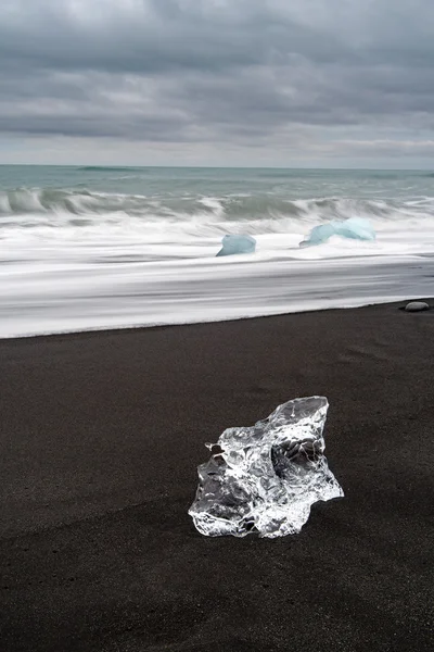 Block of ice on a solitary black beach