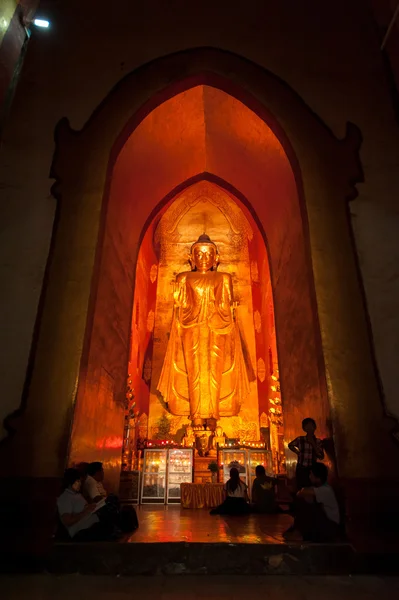 BAGAN, MYANMAR - MAT 4: Standing Buddha Kassapa at south facing part of the Ananda temple adorned by believers by sticking goledn leaves on statue on May 4, 2013 in Bagan, Myanmar.