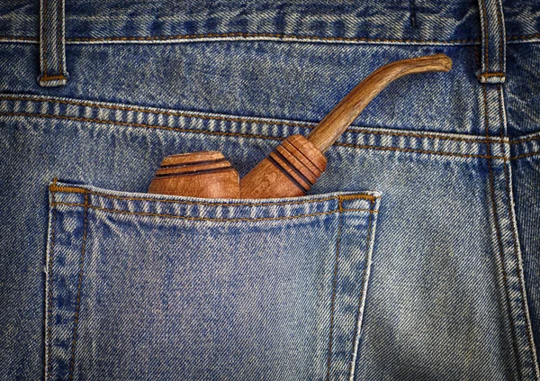 Wooden pipe for smoking in the back pocket of men\'s jeans