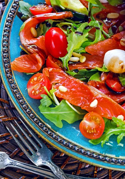 Salmon, cherry tomatoes, arugula salad, pine nuts and mozzarella