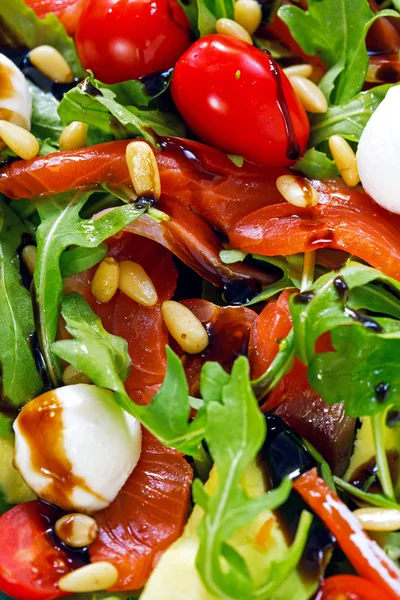 Salmon, cherry tomatoes, arugula salad, pine nuts and mozzarella