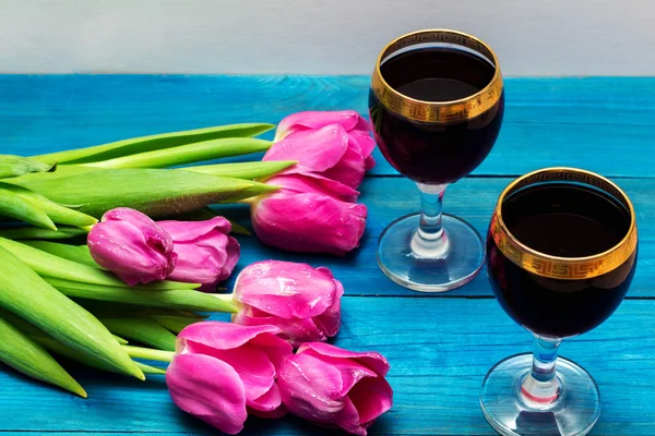 Two glasses of red wine and tulips