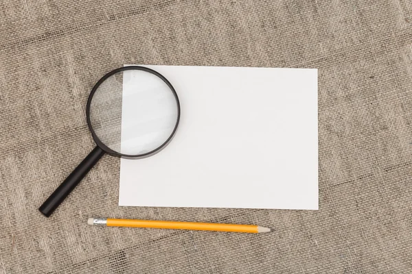 White sheet of paper and magnifying glass