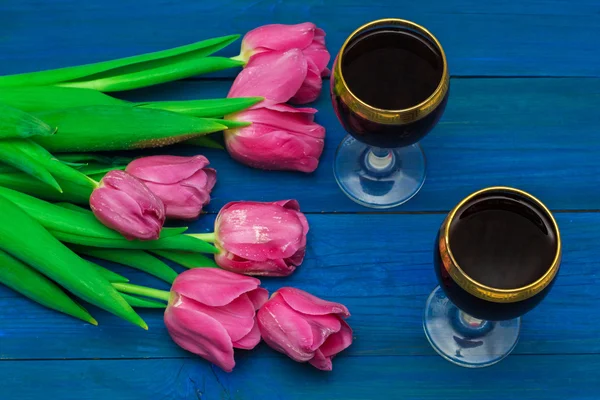 Two glasses of red wine and tulips