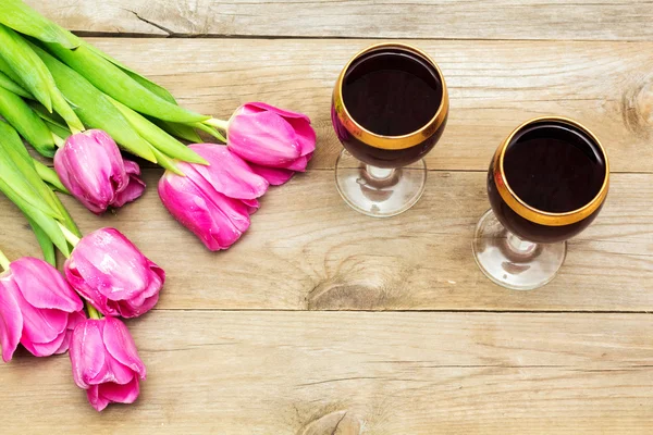 Two glasses of red wine and tulips