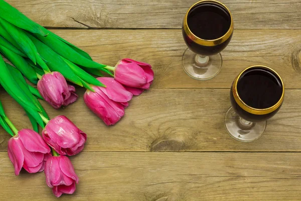 Two glasses of red wine and tulips