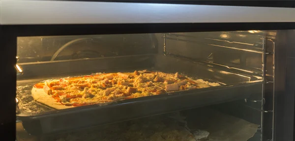 Freshly baked homemade pizza in the electric oven.