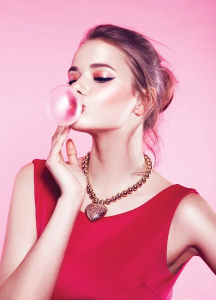 Young woman blowing bubble gum
