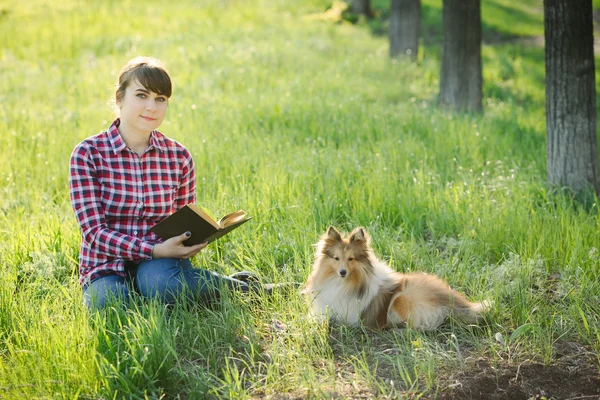 Student girl learning in nature with dog