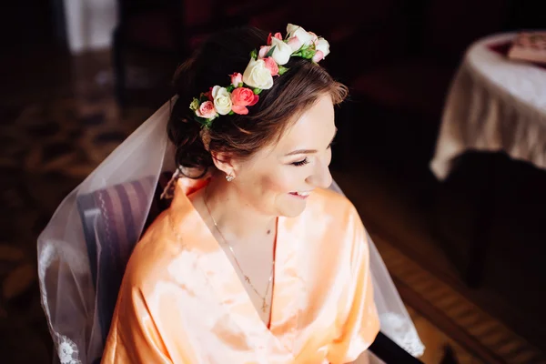 Beautiful bride with wreath of flowers in her hair preparing. Wedding day.