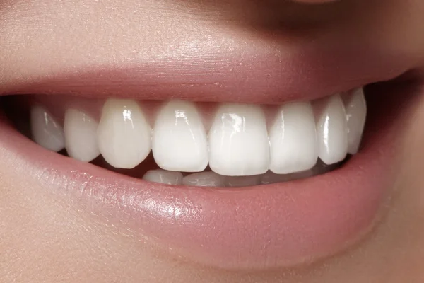 Beautiful smile with whitening teeth. Dental photo. Macro closeup of perfect female mouth, lipscare rutine